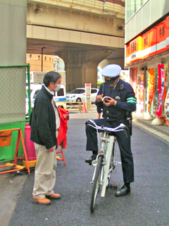 警察官に道を尋ねる人